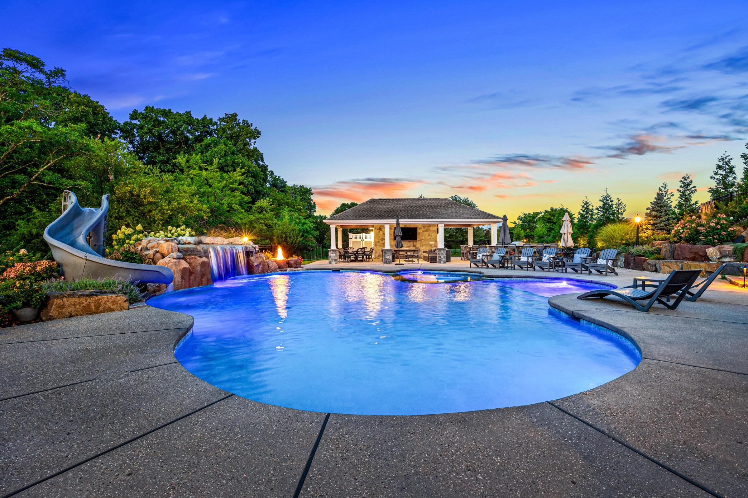 Custom pool with cascading water features and ample space for relaxation in an inviting outdoor living area.