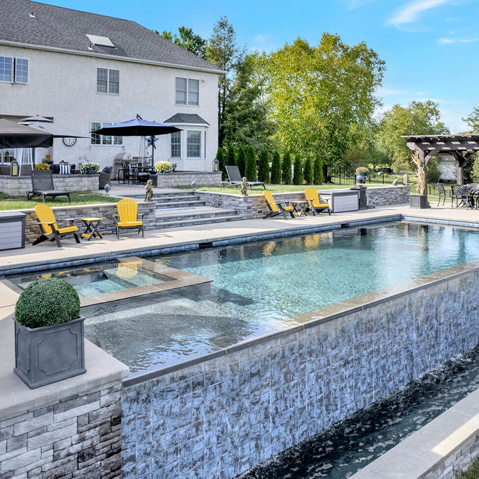 Relaxation in an outdoor living space with a custom pool, featuring a serene sunset view