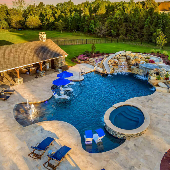 Custom pool with a waterfall feature, enhancing the relaxing ambiance of this outdoor space.