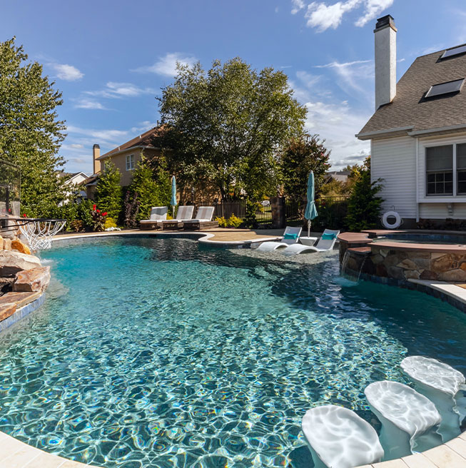 Tranquil outdoor oasis featuring a custom pool and lounge area