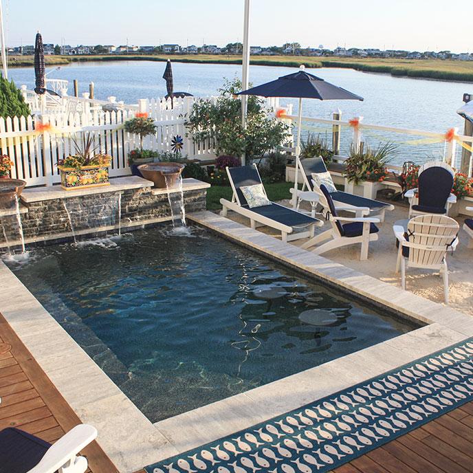 rectangular pool with waterfall next to the bay