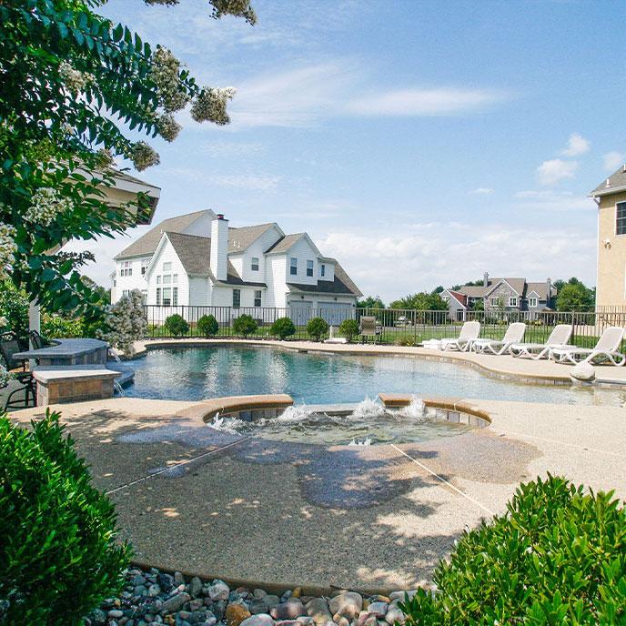 pool with hot tub and lounge chairs