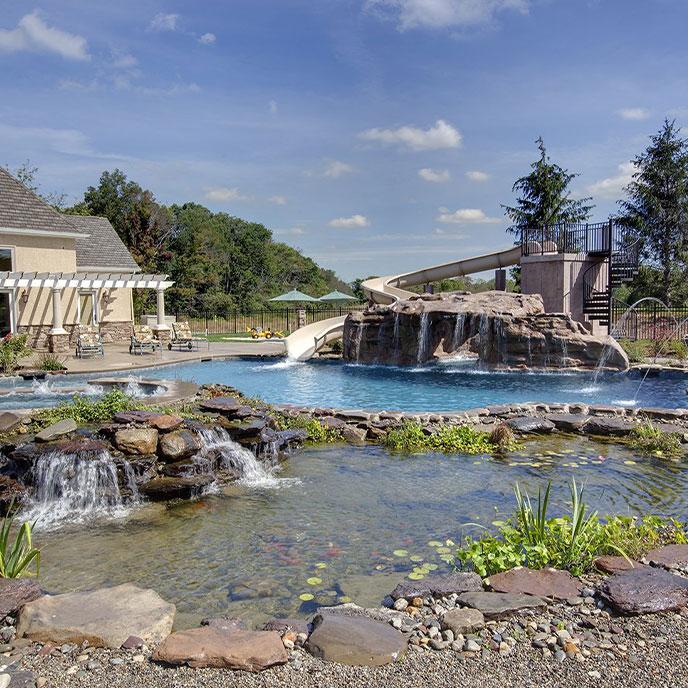 kid-friendly pool with pool house, large slide and grotto waterfall