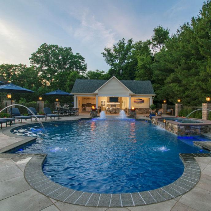 blue lit pool at night flame torches