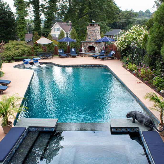 pool with stone lounge chairs and water spouts shooting over the pool