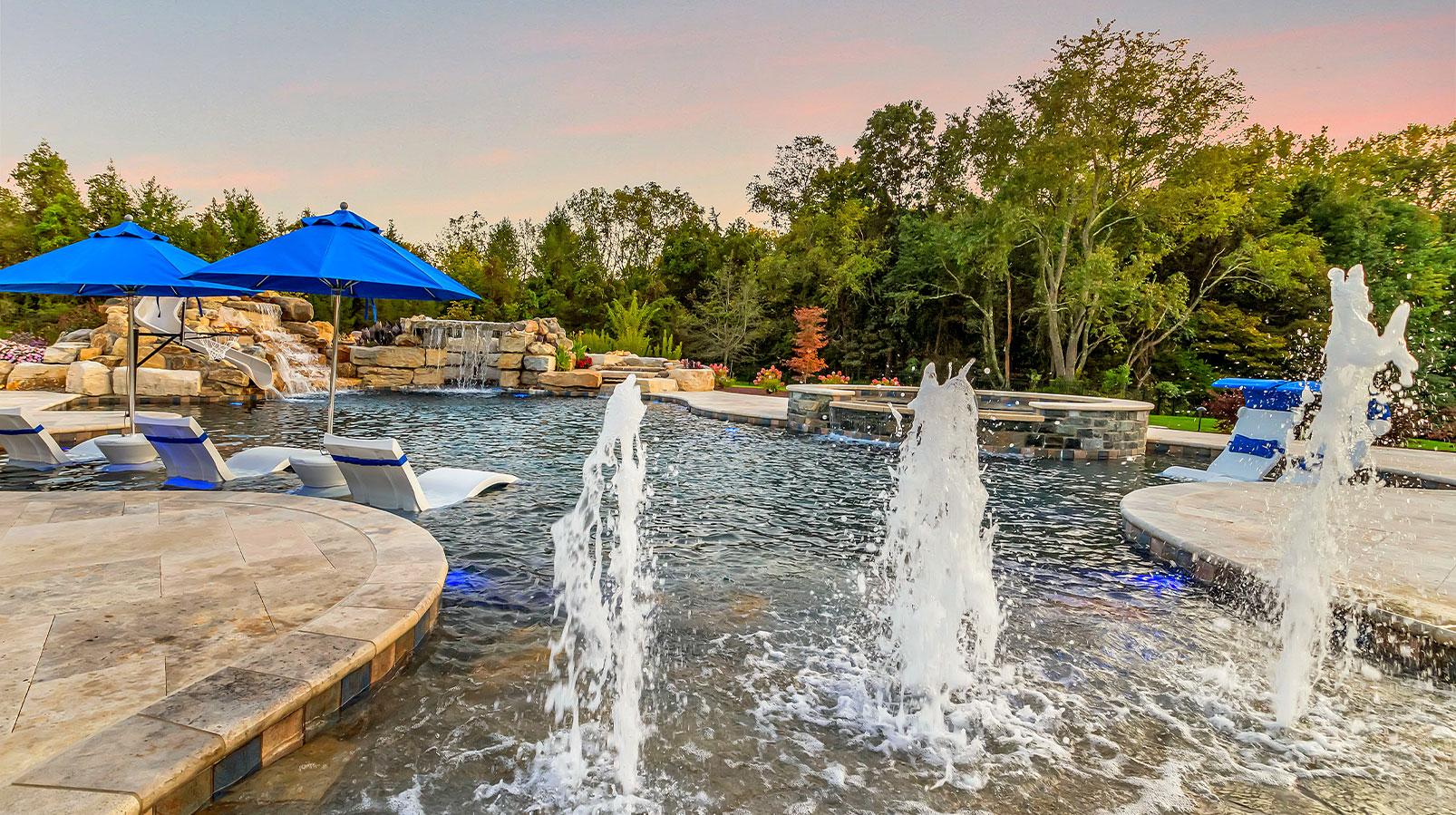 Outdoor space with a custom pool, outdoor kitchen, and dining area, creating the perfect spot for relaxation and entertaining.