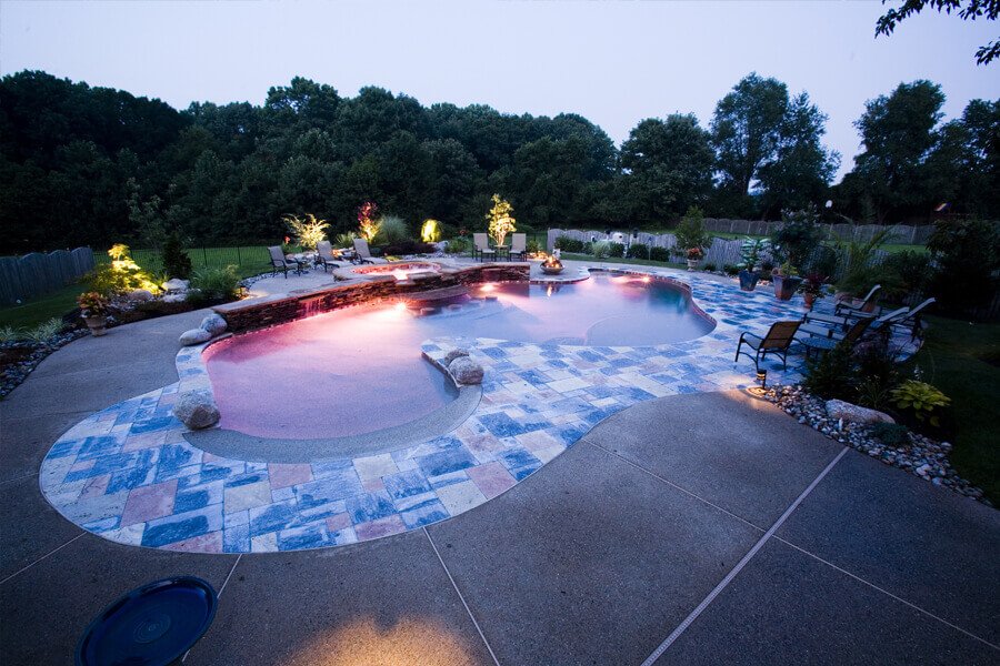 pool with beach-style entry and long, natural stone accent wall